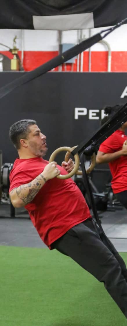 Gym member performs suspension ring exercise at Apex Performance Gym